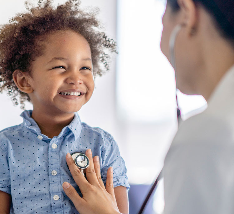 boy smiling while being treated by doctor