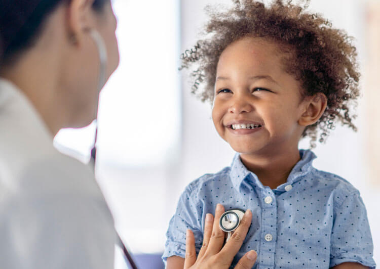 happy boy being treated by doctor with stethoscope