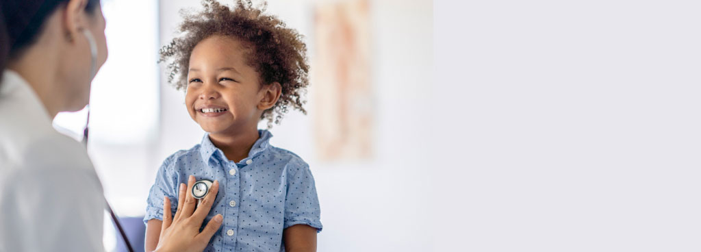 happy boy being treated by doctor with stethoscope